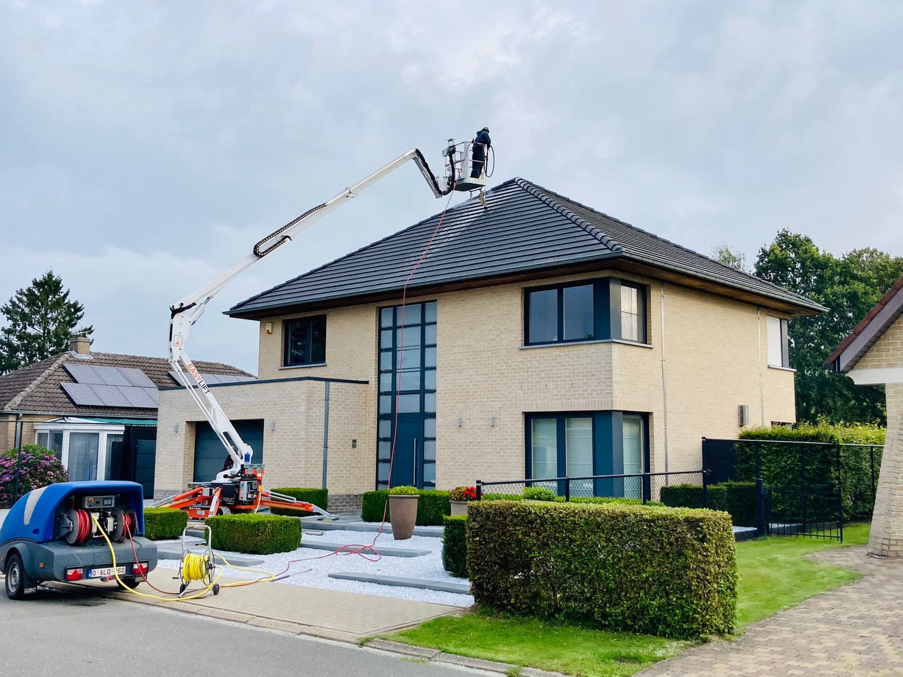 Hoogtewerker van Eco-Steam bij een woning tijdens een dakreiniging