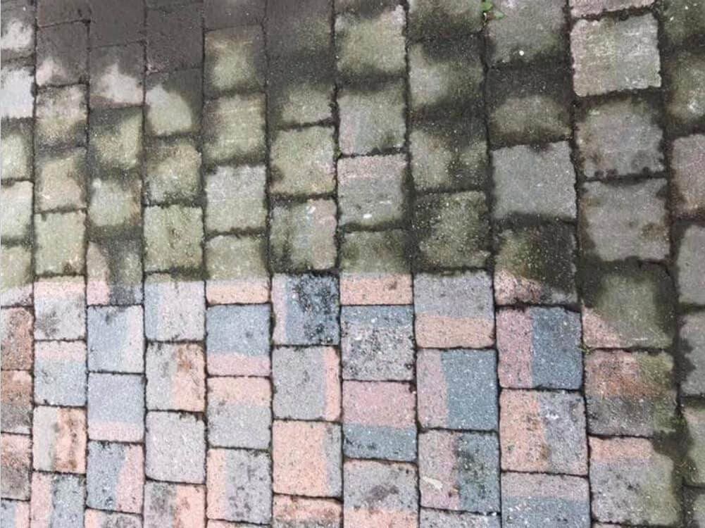Klinkers met mos, halverwege de reiniging